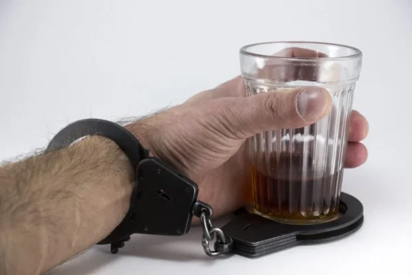 Ruka držící skleničku alkoholu