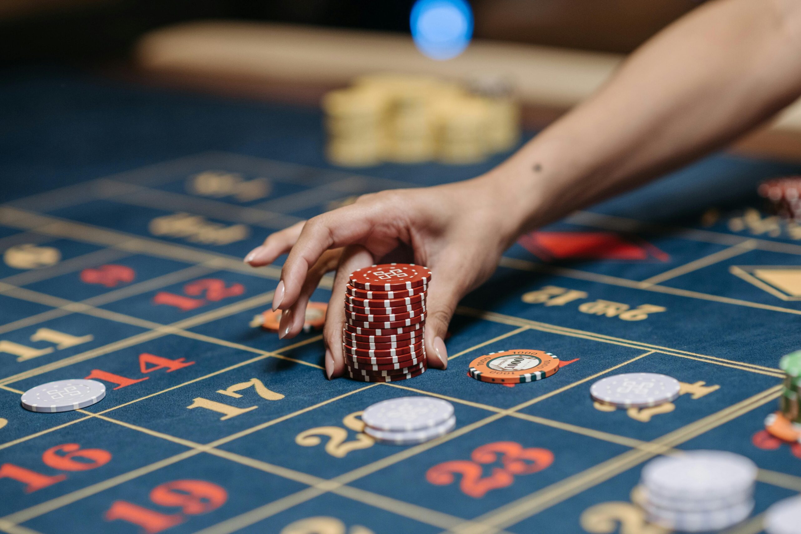 Ruka sází žetony na ruletu - léčba závislosti na gamblingu nebo patologickém hráčství